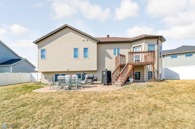 rear view of house with a wooden deck, a yard, and a patio area