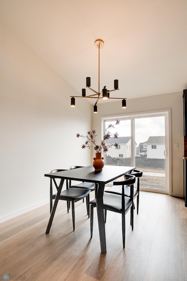 dining space with light hardwood / wood-style floors and a chandelier