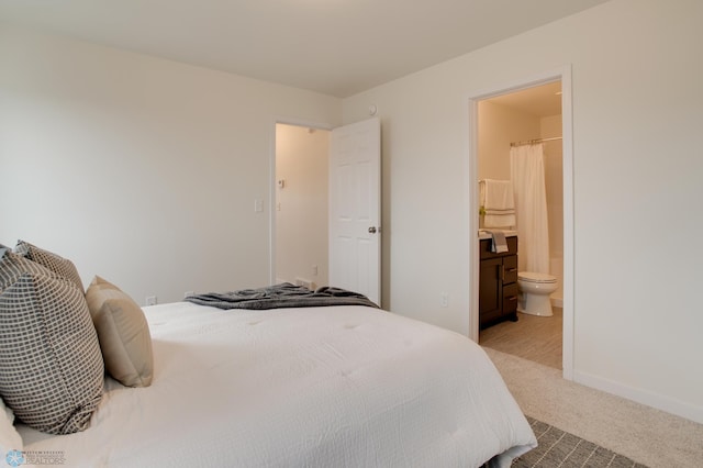 carpeted bedroom featuring ensuite bath