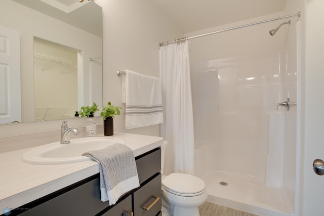 bathroom featuring walk in shower, vanity, and toilet