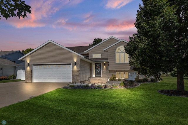 view of front of home with a garage and a yard