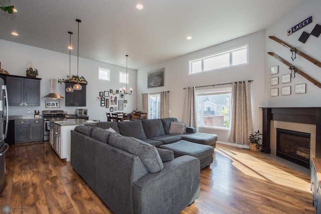 living room with a high ceiling, dark hardwood / wood-style flooring, and a chandelier