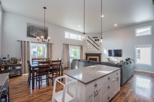 kitchen featuring white cabinets, light stone countertops, dark hardwood / wood-style flooring, and decorative light fixtures