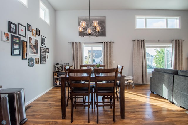 dining room with an inviting chandelier, dark hardwood / wood-style flooring, and a high ceiling