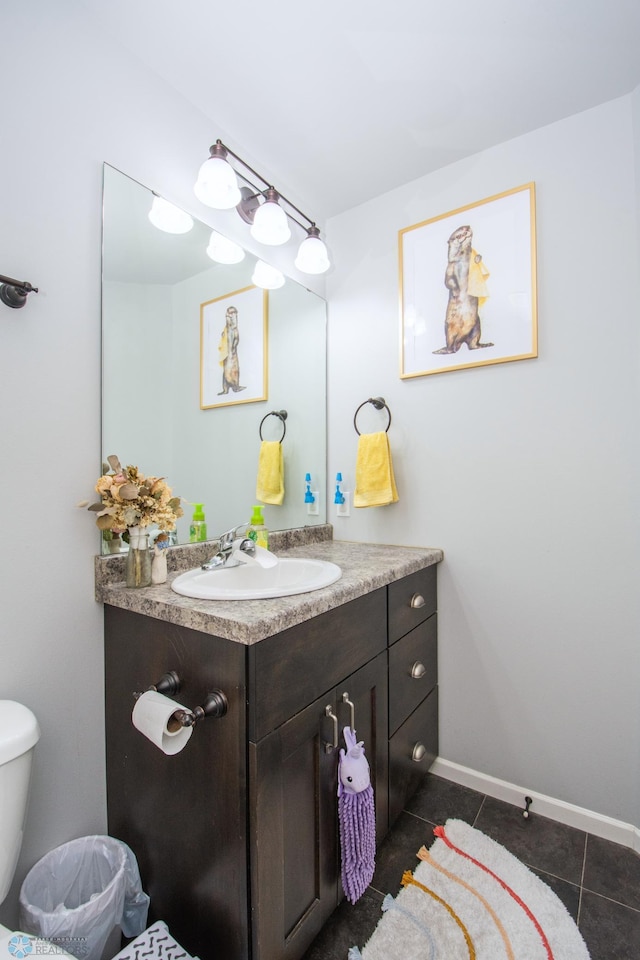 bathroom with tile patterned flooring, vanity, and toilet