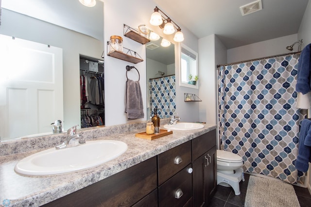 bathroom featuring walk in shower, vanity, toilet, and tile patterned floors