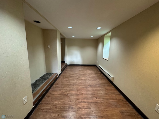 corridor featuring wood-type flooring and baseboard heating