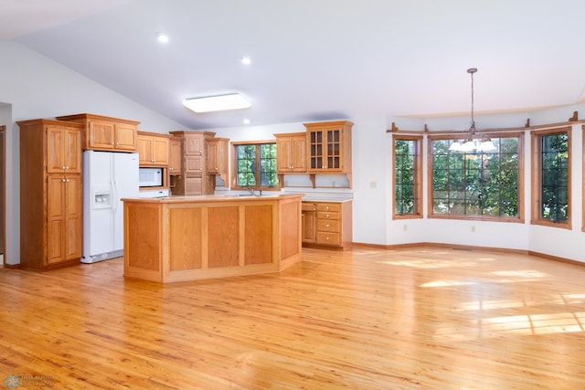 kitchen featuring white appliances, pendant lighting, a chandelier, and light hardwood / wood-style flooring