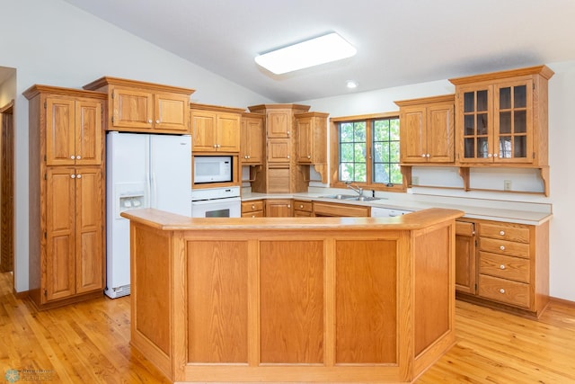 kitchen featuring light wood-type flooring, sink, lofted ceiling, a kitchen island, and white appliances