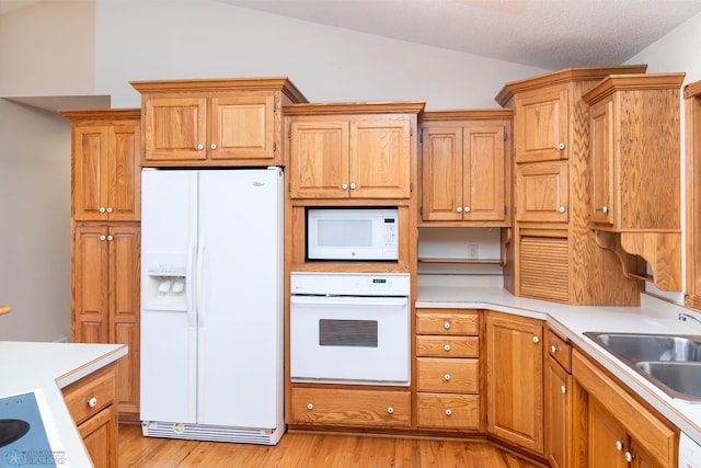 kitchen with lofted ceiling, sink, white appliances, a textured ceiling, and light hardwood / wood-style flooring