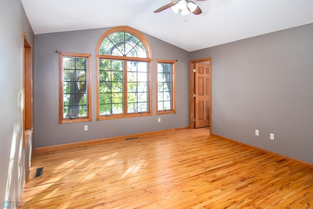 empty room featuring vaulted ceiling, light hardwood / wood-style floors, and ceiling fan