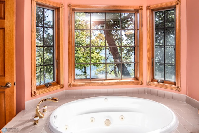 bathroom featuring tiled bath and a wealth of natural light