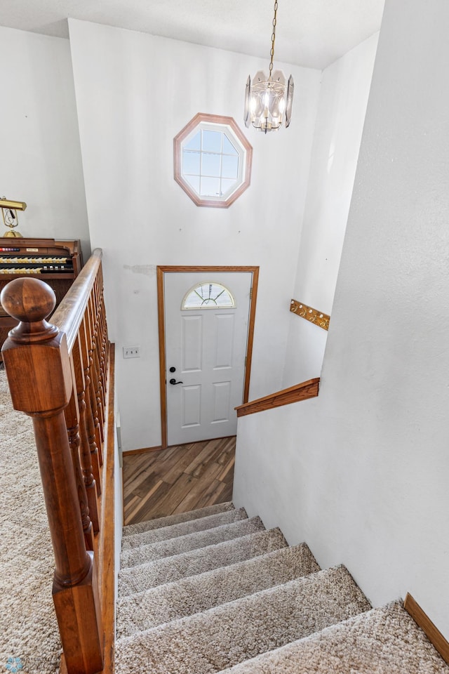 staircase with an inviting chandelier and hardwood / wood-style floors