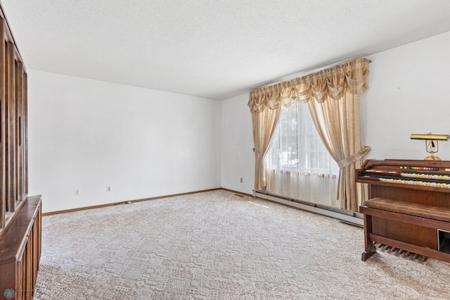 carpeted spare room featuring a textured ceiling and baseboard heating