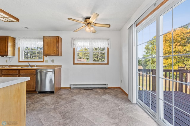 kitchen with a wealth of natural light, baseboard heating, sink, and stainless steel dishwasher