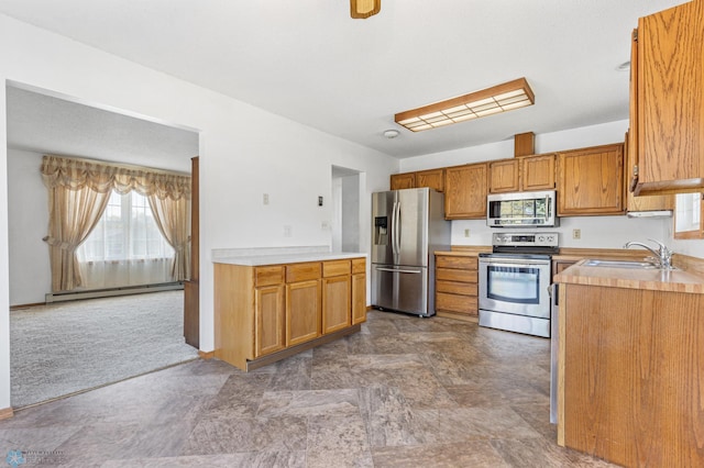 kitchen featuring carpet floors, a baseboard radiator, stainless steel appliances, and sink