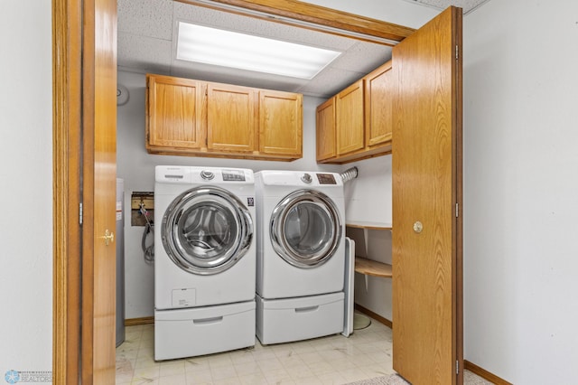 washroom with washer and clothes dryer and cabinets