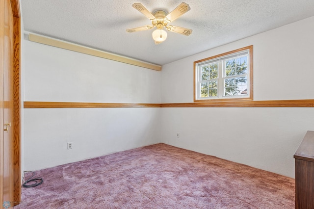 carpeted empty room featuring ceiling fan and a textured ceiling