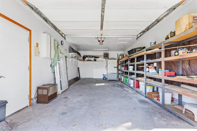 garage featuring white refrigerator and a garage door opener