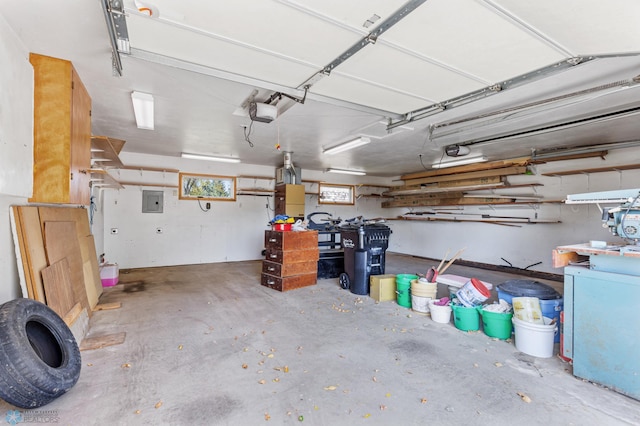 garage featuring fridge, a garage door opener, and electric panel