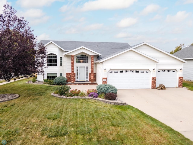 split foyer home featuring a garage and a front yard