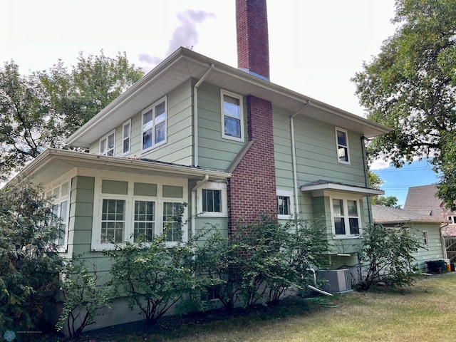 view of home's exterior featuring central AC unit and a lawn