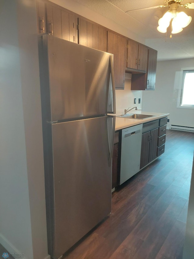 kitchen with sink, stainless steel appliances, baseboard heating, dark hardwood / wood-style flooring, and ceiling fan