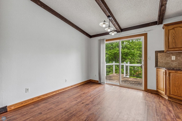 interior space featuring wood-type flooring, a textured ceiling, and beamed ceiling