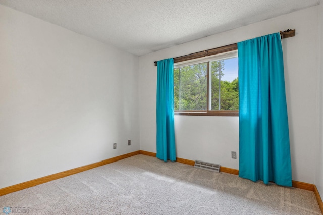 spare room featuring a textured ceiling and carpet floors