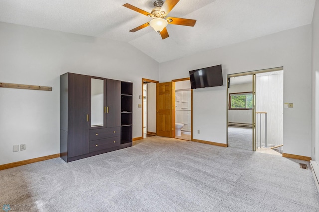 unfurnished bedroom with ceiling fan, baseboard heating, light carpet, ensuite bath, and vaulted ceiling