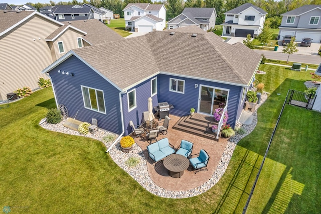 rear view of property featuring a lawn, a patio, and a garage