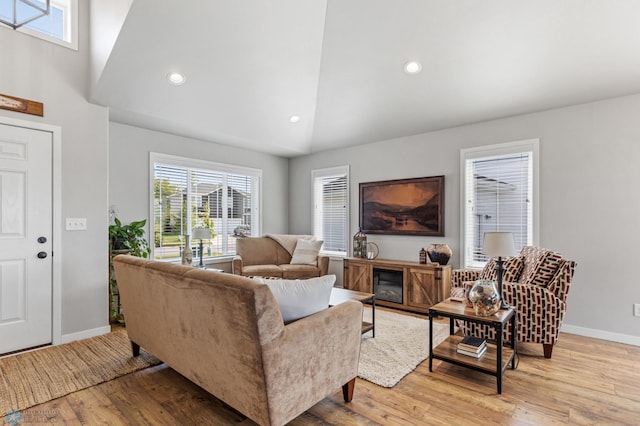 living room featuring light hardwood / wood-style flooring and high vaulted ceiling