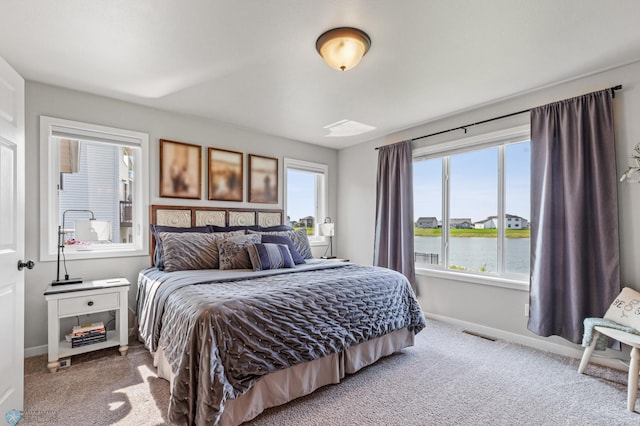 carpeted bedroom with a water view