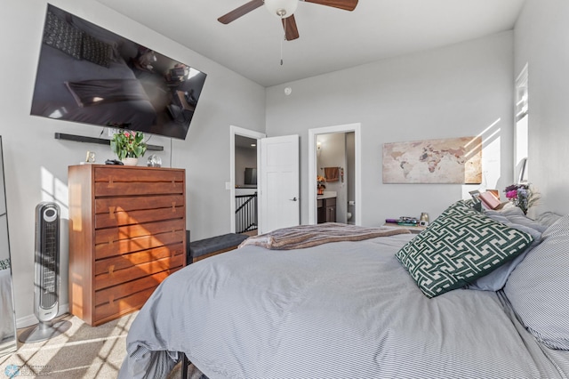 bedroom featuring light colored carpet, ceiling fan, and ensuite bathroom