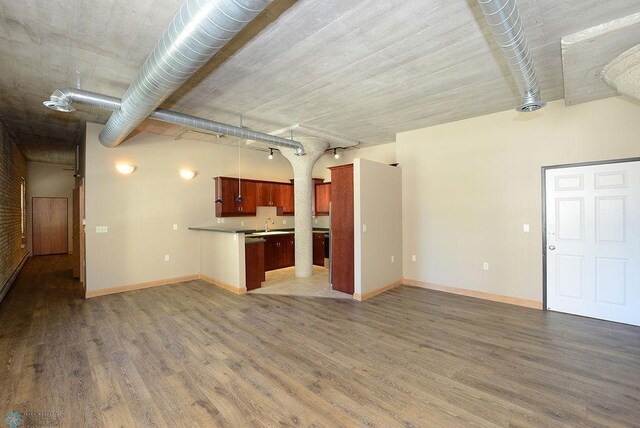 unfurnished living room with wood-type flooring and rail lighting