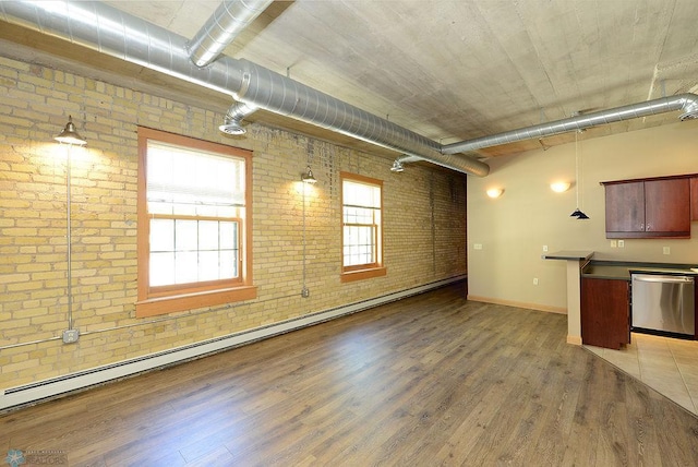 unfurnished living room with brick wall, a baseboard radiator, light hardwood / wood-style flooring, and plenty of natural light