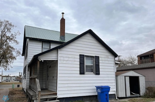 back of property with a storage shed