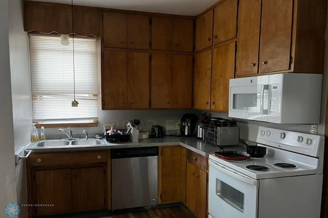 kitchen with dark wood-type flooring, sink, white appliances, and a wealth of natural light