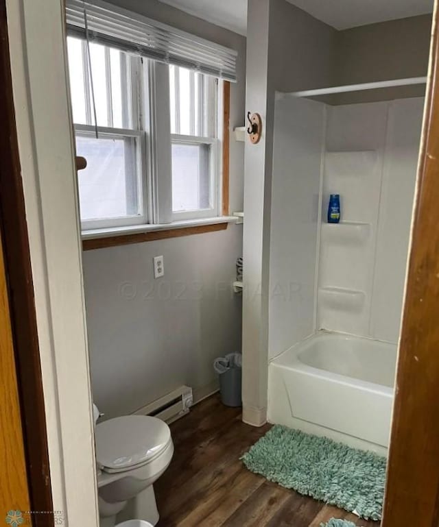 bathroom with baseboard heating, bathing tub / shower combination, hardwood / wood-style floors, and toilet