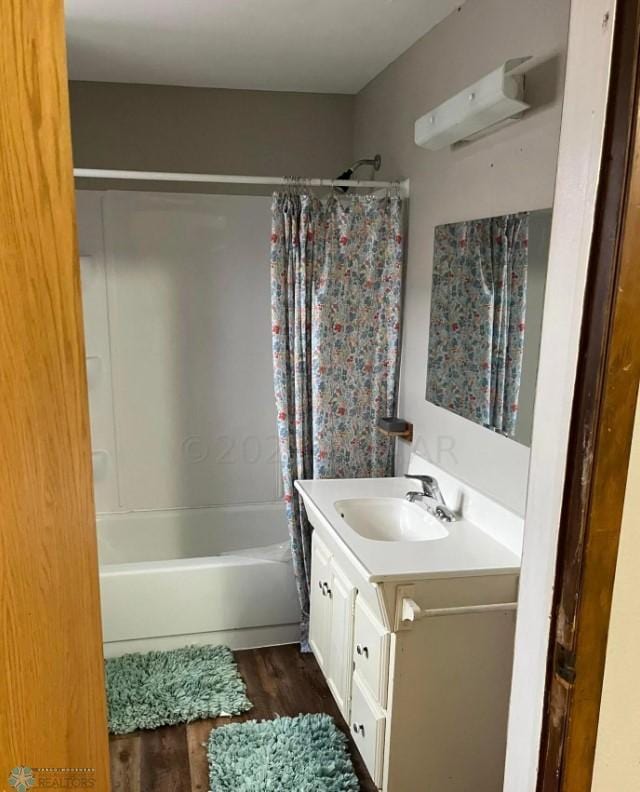 bathroom featuring shower / bathtub combination with curtain, hardwood / wood-style floors, an AC wall unit, and vanity