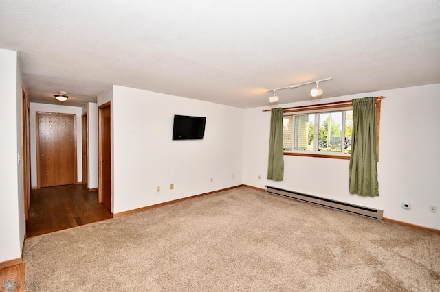 carpeted spare room featuring a textured ceiling and a baseboard radiator