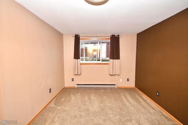 spare room featuring a baseboard radiator, carpet, and a textured ceiling