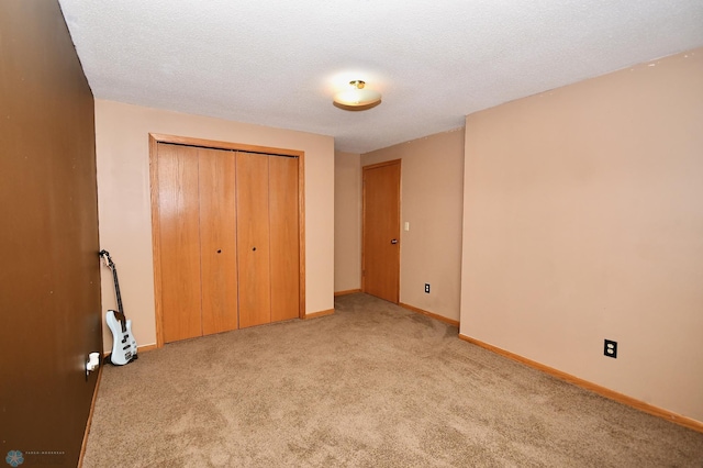 unfurnished bedroom with a textured ceiling, light colored carpet, and a closet