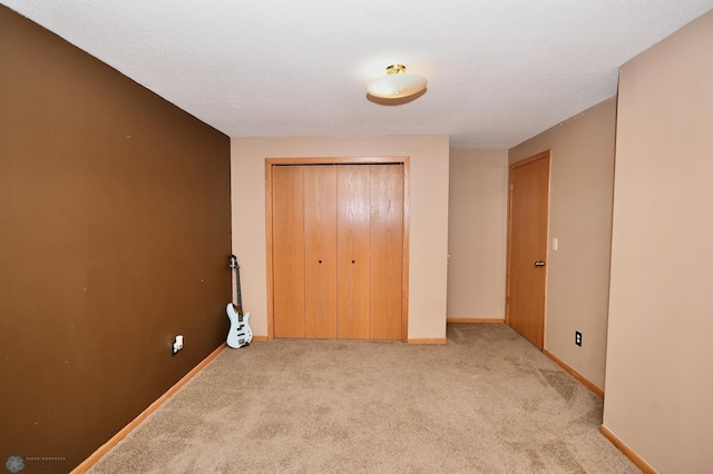 unfurnished bedroom featuring light carpet, a textured ceiling, and a closet