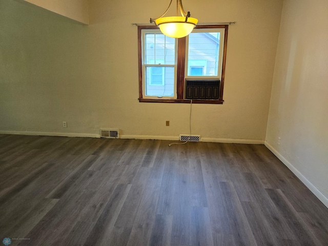 empty room featuring cooling unit and dark hardwood / wood-style flooring