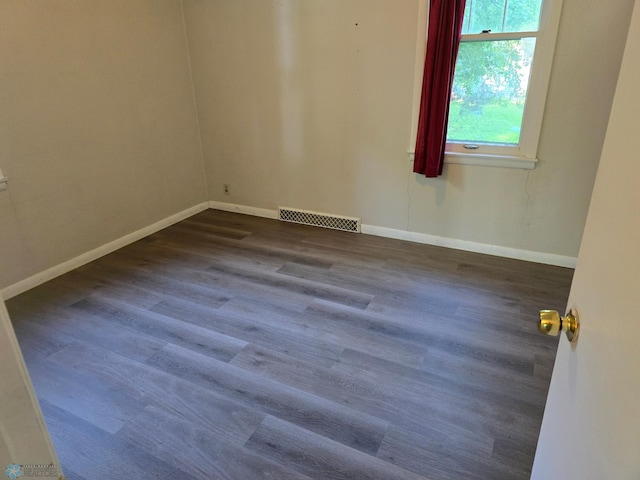 unfurnished room with dark hardwood / wood-style flooring