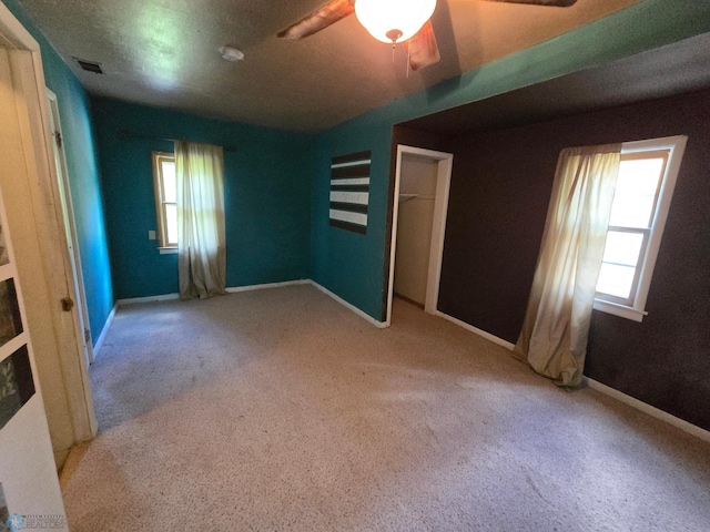 empty room featuring ceiling fan and light colored carpet