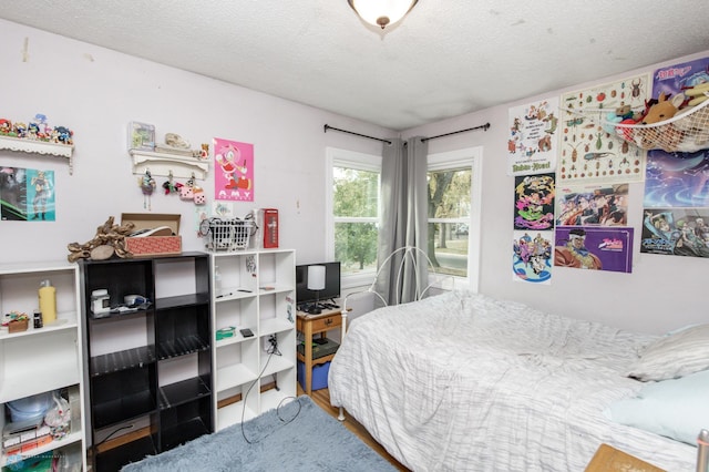 bedroom with wood-type flooring and a textured ceiling