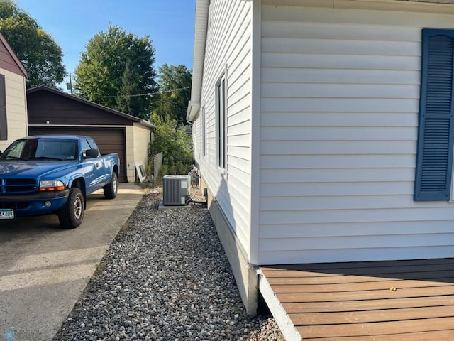 view of side of property featuring central AC unit, an outdoor structure, and a garage