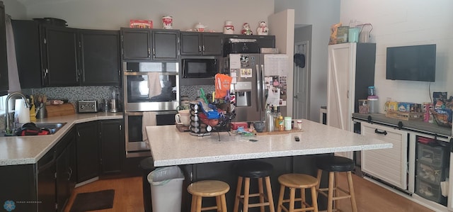 kitchen featuring a center island, sink, stainless steel appliances, and tasteful backsplash